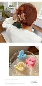 Cute heart-shaped hair claw clip for women, stylish transparent acrylic hair styling accessory.