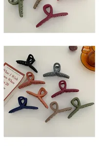 Detailed view of matte hair claw clips in various colors arranged neatly on a clean white surface.