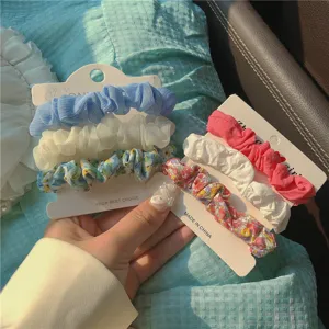 Floral scrunchies detail view, set of 3 hair ties in blue and pink tones for stylish daily wear.
