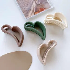 Primo piano dettagliato di mollette per capelli a cuore opache in colori chic, acconciatura elegante.