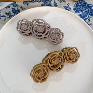 Vista dettagliata molletta capelli fiore rosa goffrata, design dolce per acconciature.