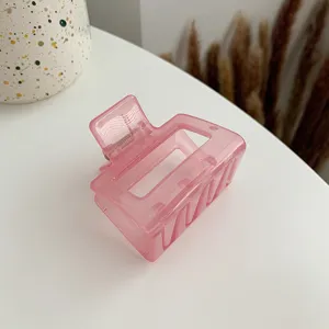 Detailed close-up view of the translucent pink acrylic hair claw clip showcasing glossy texture.