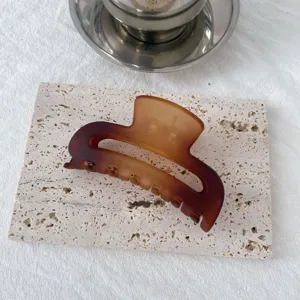 Detail shot of the gradient double-color hair claw clip on stone surface, elegant hair tool.
