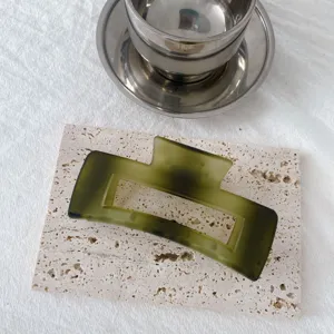 Green matte hair claw clip detail shot, elegant geometric resin jaw clip for thick hair styling.