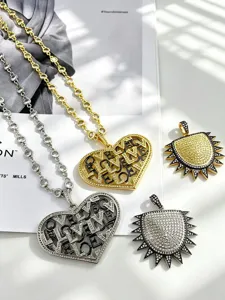 Detailed view of luxury cubic zirconia station chains with hollow LOVE heart and sun spike pendants.