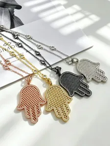 Close-up of fashionable Hamsa hand pendant necklaces with sparkling zircons in four chic colors.
