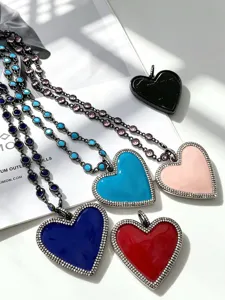 Detailed close-up of colorful enameled heart pendant necklaces with sparkling rhinestone borders.