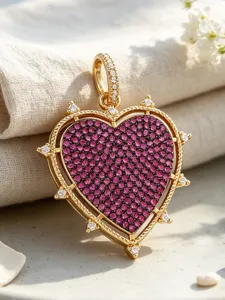 Close-up detail of heart-shaped gold pendant with pink pavé zirconia and sparkling stone accents.