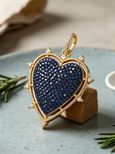 Close-up detail of the gold heart pendant with dark blue pavé stones and white zirconia.
