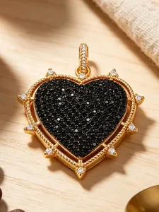Close-up view of a stunning gold heart pendant featuring black pavé stones and crystal accents.