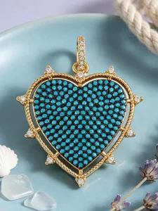 Exquisite heart-shaped rhinestone pendant detail, shimmering blue pavé stones, gold tone charm.