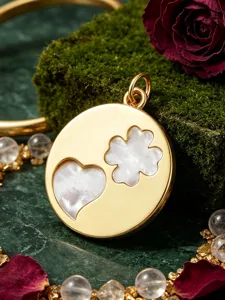Gold-plated metal pendant featuring white mother-of-pearl heart and four-leaf clover inlay details.