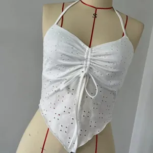 White halter crop top featuring front drawstring and delicate eyelet cutout embroidery.