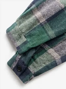 Detailansicht der Manschette eines karierten Herren Flanellhemdes in Gruen mit Knoepfen.