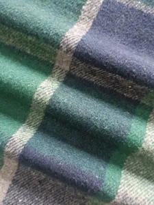 Nahaufnahme der feinen grün-blauen Karo-Flanellstoff-Textur mit weichen Textilfasern.