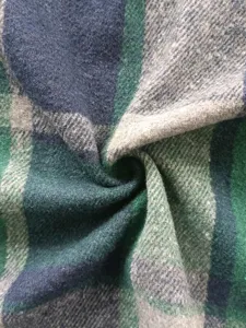 Detailansicht des grün-blauen karierten Wollstoffs, ideal für stilvolle Winterjacken.