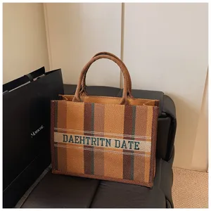 Stylische Segeltuchtasche mit Streifenmuster und gestickten Buchstaben für den Alltag.