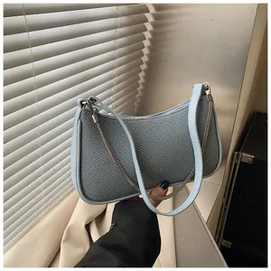 Nahaufnahme der stilvollen blauen strukturierten Tasche mit feiner Kette und Material.