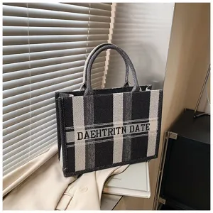 Schwarze und weiße Leinwand-Tragetasche, lässige Handtasche, große Kapazität für Pendler.