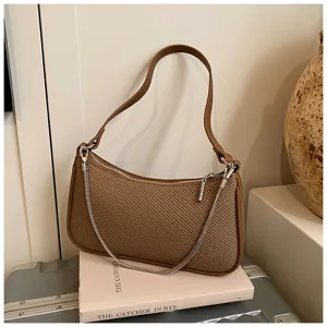 Nahaufnahme einer braunen Schulter-Damentasche mit stylischer Metallkette und Reißverschluss.