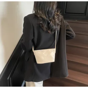 Detail der minimalistischen Umhängetasche mit eleganten Prägemustern und feinem Gurt.