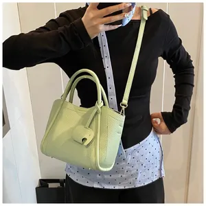 Stylish light green leather tote bag with top handles, shoulder strap and cute elephant charm.