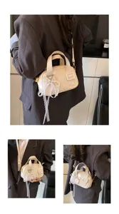Detail view of the soft leather handbag featuring elegant lace pearl pendant and chic design.