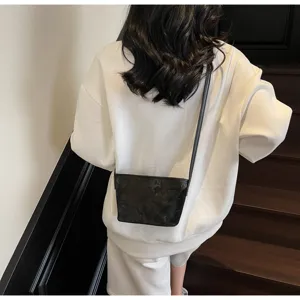 Minimalistische schwarze Umhängetasche für Damen, stilvolle Schultertasche mit Muster.