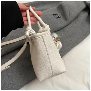 Borsa a secchiello in pelle martellata bianca con manico e tracolla, stile casual chic per ogni giorno.