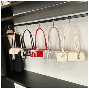 Stylish patent leather baguette shoulder bag with cute lace bow, versatile trendy underarm bag.