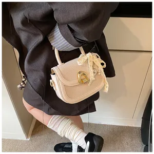 Toma detallada de un elegante bolso de silla tejido beige con lazo de perlas.