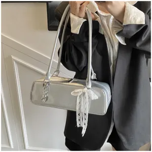 Silver patent leather baguette shoulder bag with chic bow and metal charm for daily fashion.