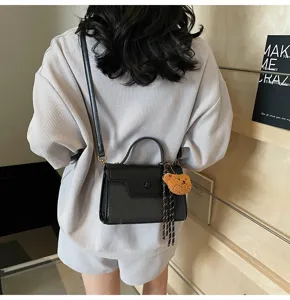 Black PU leather top handle shoulder bag for women with chic texture and cute bear charm.