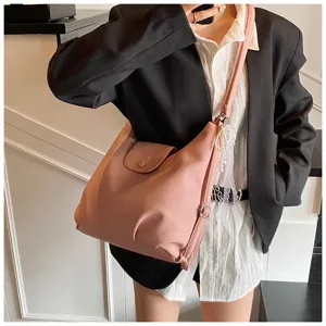 Detailed view of the pink convertible shoulder bag with pearls lace charm and soft leather.