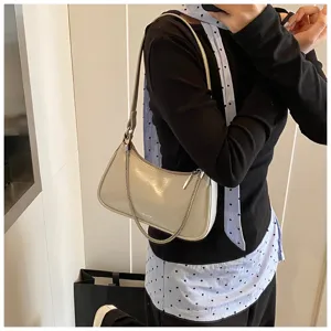 Vista detallada del elegante bolso de hombro de cuero con cadena elegante y acabado.