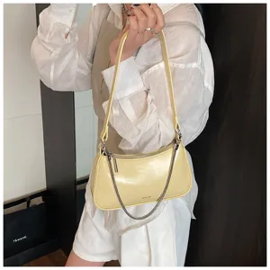 Vista detallada del bolso de hombro amarillo para mujer en cuero suave con cadena metálica.