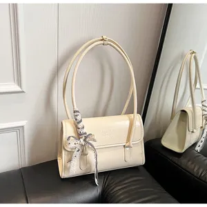 Chic off-white patent leather shoulder bag with double handles and elegant bow detail.