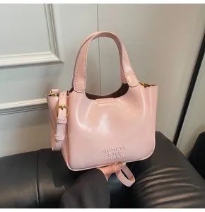 Detailansicht der rosa PU-Leder Handtasche mit Textur, Tragegriff und geprägtem Logo.