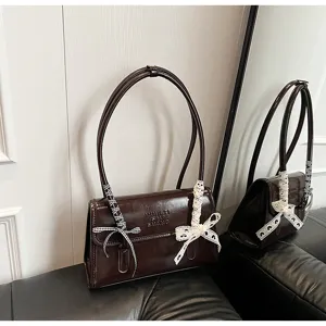 French niche chic brown leather shoulder bag with dual straps and ribbon bow decoration.