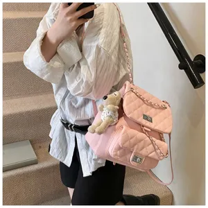 Sac à dos rose en cuir matelassé avec chaîne pour femmes, chic avec pendentif ours et serrure.