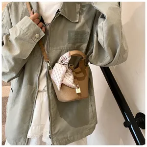 Detailansicht einer schicken Leder Eimerhandtasche mit Tragegriff, Vorhängeschloss und Tuch.