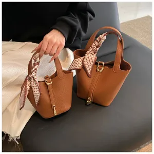 Modische braune Leder Eimer Tasche für Damen, schicke Handtasche mit Tuch und Metallschloss.