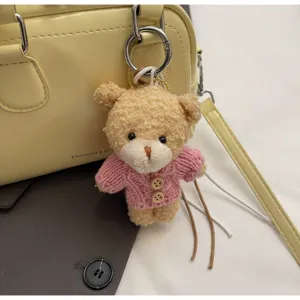 Primo piano di una borsa Boston gialla con grazioso portachiavi a forma di orsetto rosa.