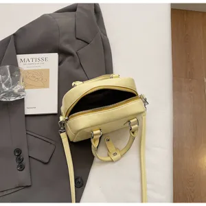 Vista dettagliata della borsa Boston gialla con chiusura a zip, dettagli del manico e accessori.