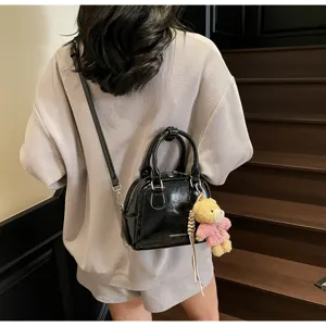 Borsa Boston in pelle verniciata nera da donna, borsa chic con simpatico ciondolo orsetto.