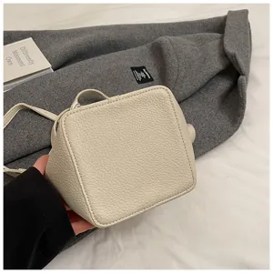 Mini beige Leder Eimer Tasche mit Griff und Umhängegurt, schicke Alltagshandtasche.