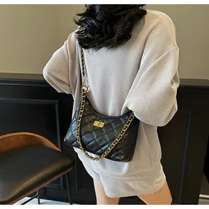 Detailed view of the black quilted shoulder bag with gold chain and turn-lock closure.