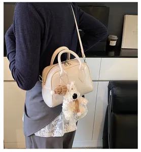 Soft leather bowling bag with cute puppy charm, stylish shoulder bag for women daily commute.