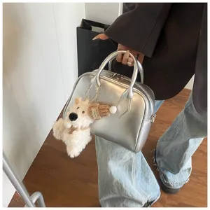 Silver soft leather bowling bag detail, stylish women crossbody handbag with cute plush charm.