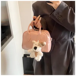 Pink patent leather bowling bag for women, stylish handbag with cute plush dog keychain charm.